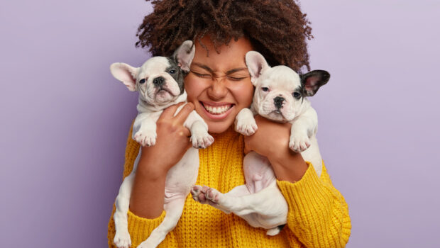 Woman holding two puppies